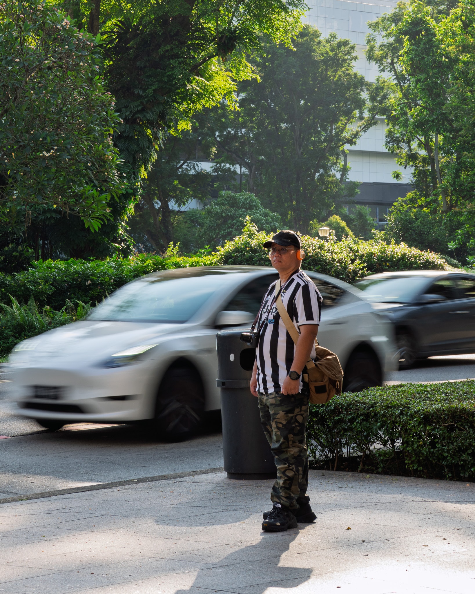 Man standing in parking lot with cars
